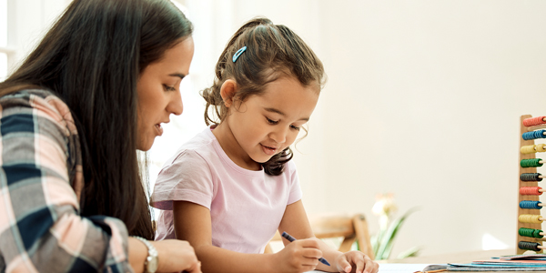 Mãe e filha desenvolvendo atividades de alfabetização