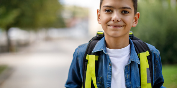 menino de cerca de 7 ou 8 anos indo pra escola coma mochila nas costas