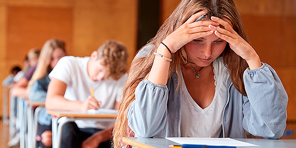 Menina fazendo prova e o Colégio Anglo Itu reforça sobre os impactos do estresse na adolescência