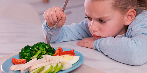 menino com garfo para escolher alimentos no prato de comida