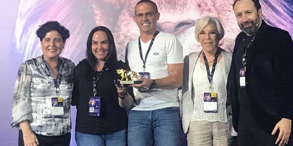 Diretoria do Colégio Anglo Itu recebe troféu do Leão de Ouro nas mãos.