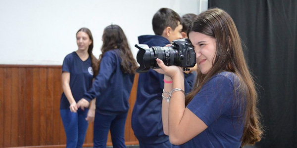 menina com máquina fotográfica profissional tirando foto 